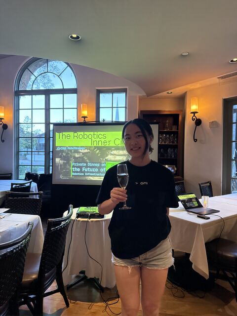 Nicole raising a glass in front of the Robotics Inner Circle slide